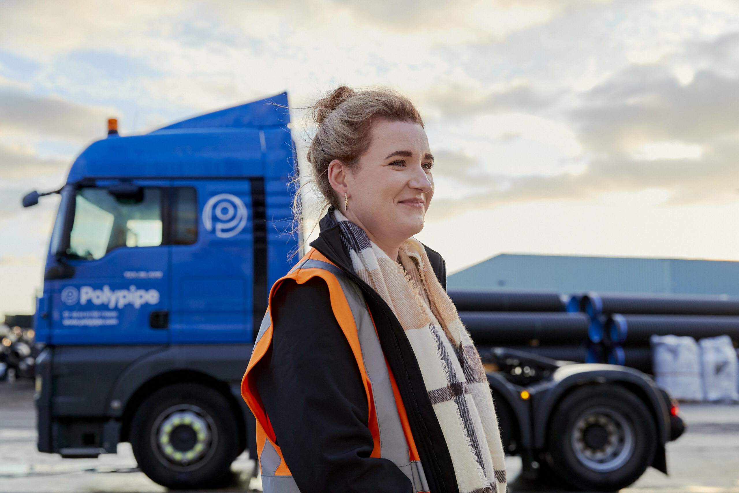 Woman smiling next to a Polypipe truck.